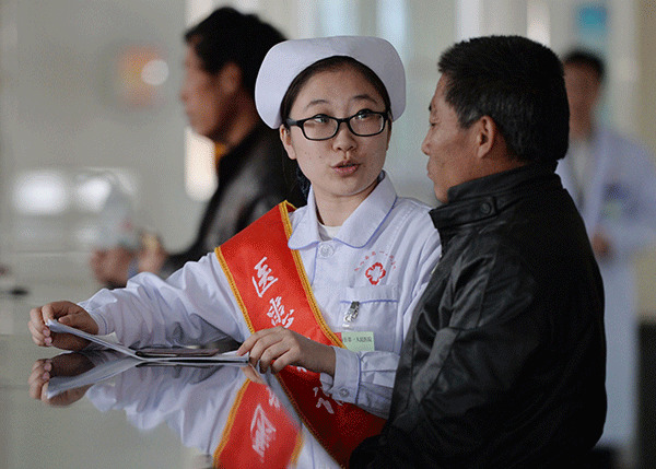 A nurse explains how to claim reimbursement from the national medical insurance program in Longxi County No 1 People's Hospital in Gansu province. (Photo/Xinhua)