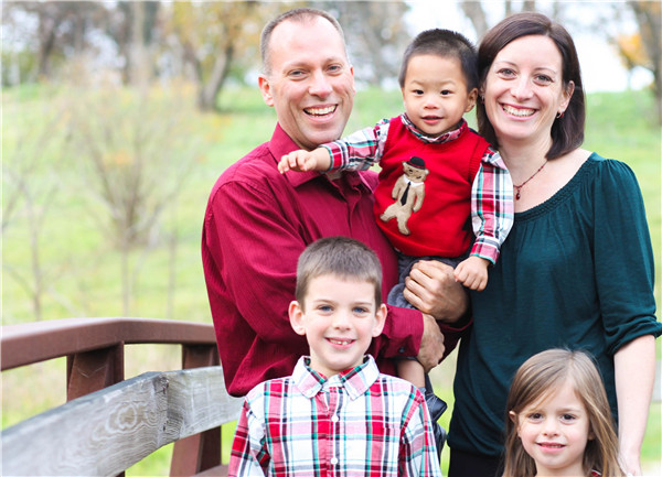 Two year old Xiao Long (center) now lives with his foster family in America. (Photo Provided To China Daily)