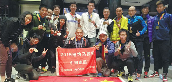 Tian Tongsheng (center, holding flag) poses with marathon runners from China after the New York race. Photos Provided to China Daily