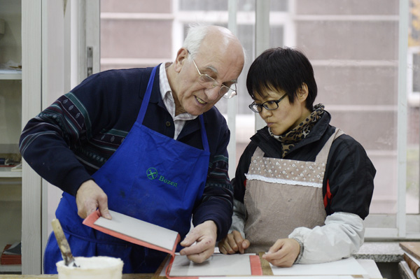 Friedbert Ewertz, a monk from Germany, demonstrates how to bind gospel books.(Photo by Wei Xiaohao/China Daily)