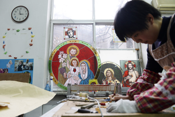 A nun makes stained glass decorations in the seminary's art department. (Photo by Wei Xiaohao/China Daily)