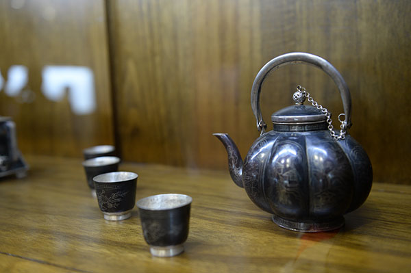 A tea set made by Silver-inlaid Black Copper is displayed in the learning center of Jin Yongcai, Nov 19, 2015. (Photo by Tan Qing/For chinadaily.com.cn)