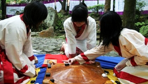 Three people play Danqi. (Photo/Xinhua)