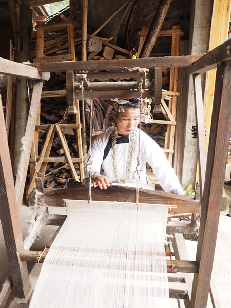 A Dong ethnic woman weaves in the traditional way. ZHANG JIHUI/CHINA DAILY