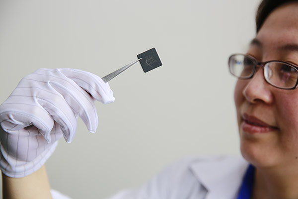 A technician displays a domestically developed chip in Jiujiang, Jiangxi province. Made-in-China chips generated $32.5 billion in sales last year. (ZHANG HAIYAN/CHINA DAILY)