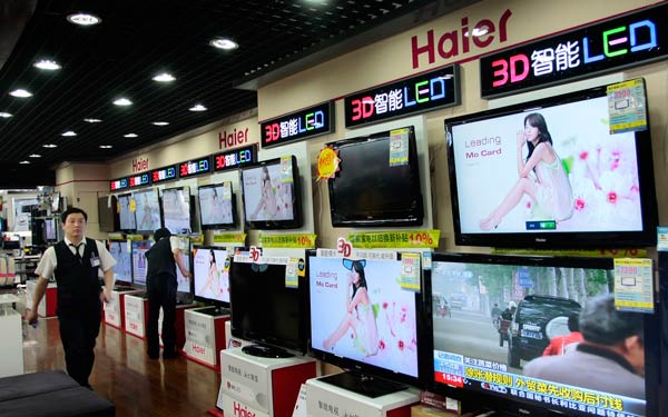 Sales people inspect Haier-branded 3D smart TV products during a preparatory work before business opening at an electrical appliances department store in Nanjing, Jiangsu province. (Photo/Provided to China Daily)