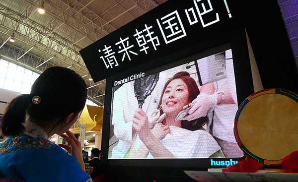 A visitor watches a South Korean plastic surgery promotional film at an international travel expo in Beijing.(Photo provided to China Daily)