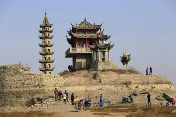 Visitors can visit a scenic spot in Poyang Lake, Jiangxi province, by foot and bike because of the falling water level in the lake. (Photo/CHINA DAILY)