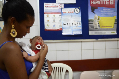 Gabrielly Santana da Paz holds her child who suffered microcephaly while waiting for examination at the Oswaldo Cruz Hospital, in Cabo de Santo Agostinho, 35 km from Recife, capital of Pernambuco in northeastern Brazil, on Feb. 1, 2016. (Photo/Xinhua