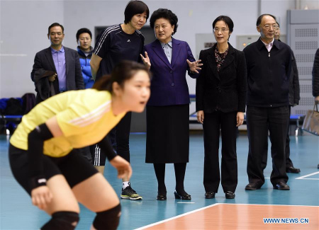 Chinese Vice Premier Liu Yandong(3rd R) exchanges views with China's national women's volleyball head coach Lang Ping(4th R) when she views the training of national women's volleyball team in Beijing, capital of China, Feb. 18, 2016. (Photo: Xinhua/Gong Lei)