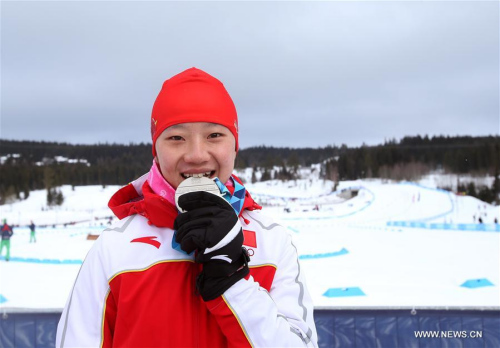 Chi Chunxue of China bites her medal after the ceremony for the women's Cross-Country Skiing Ladies' 5km Free at Lillehammer 2016 Winter Youth Olympic Games in Lillehammer, Norway on Feb. 18, 2016. Chi took the silver medal with a time 13:29.9. (Photo: Xinhua/Han Yan)