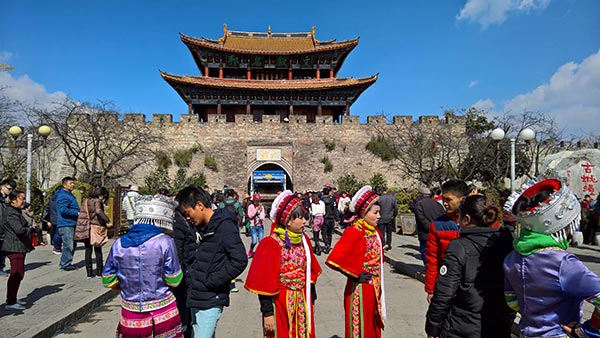 Tourists and local people in ethnic attire at the ancient town of Dali, a Bai ethnic prefecture in Yunnan province. Dali is a hot spot drawing tourists from both home and abroad for its natural landscape and rich cultural legacy. (Photo by Du Wenbin/China Daily)