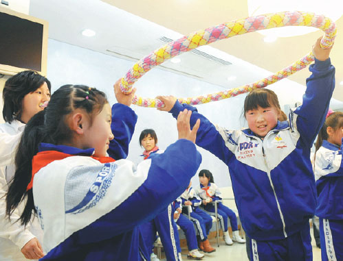 Volunteers play games with students from Beijing Zhiquan School in December 2009. Yuan Zhou / For China Daily