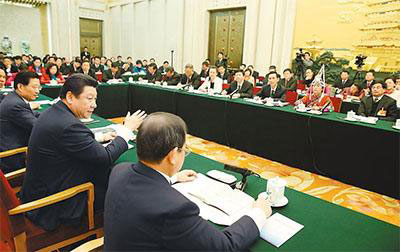 Chinese President Xi Jinping, also general secretary of the Communist Party of China (CPC) Central Committee and chairman of the Central Military Commission, reviews the work report of the State Council together with National People's Congress (NPC) deputies from Jiangxi province during the third session of the 12th NPC, in Beijing, March 6, 2015. (Photo/People's Daily Online)