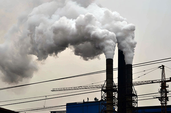 Smoke is emitted from chimneys at Gengchen Casting Materials Corp in Jinan, Shandong province, as lingering smog shrouds the city. (Photo: Xinhua/Guo Xulei)