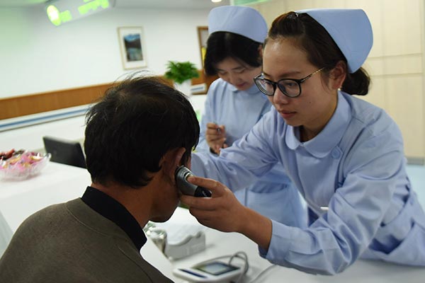 A nurse measures body temperature of patients at a medical center in Hangzhou, Zhejiang province. LONG WEI / FOR CHINA DAILY