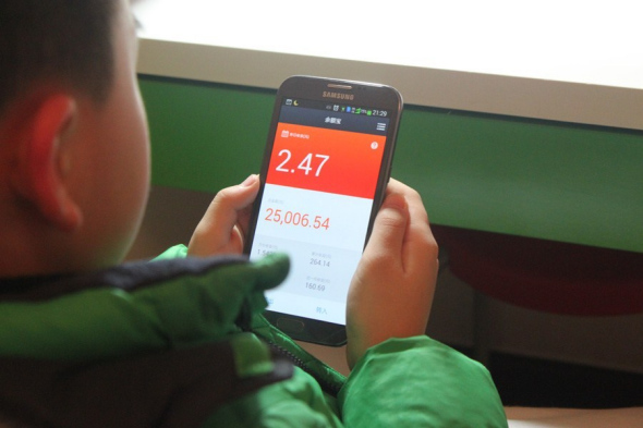 Jerry Jiang, a 9-year-old Shanghai primary school pupil, checks the rate of return on Yu'ebao, an online mutual fund.  Jiang Jun