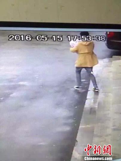 Surveillance camera captures the process of a woman in yellow carrying the new born baby away. (Photo/Chinanews.com)