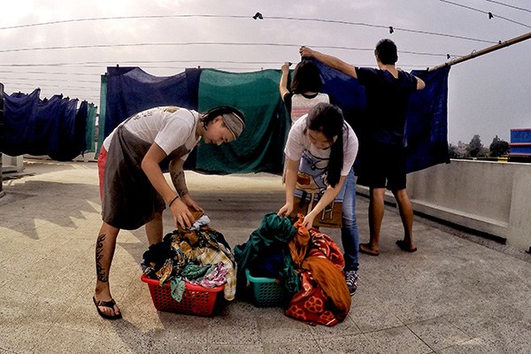 Liao Xiaohan (center), hangs up laundry on the rooftop of a hospice in Kolkata, India, with other volunteers during her gap year in 2015. The hospice was established by Mother Teresa in the 1950s. Provided to CHINA DAILY