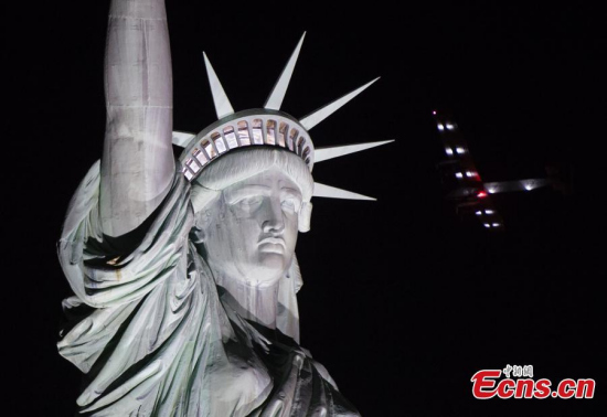 The Solar Impulse 2 aircraft flies over the Statue of Liberty before landing at JFK airport June 11, 2016 in New York. (Photo/Agencies)