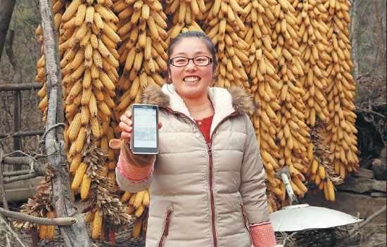 Chengxian villager Su Yanyan shows her online store on her smartphone. Many local famers have improved their standards of living through e-commerce. Xiao Zhengqiang/Xinhua