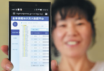 A member of staff at Anhui's Jinzhai county government displays the Gansu poverty database. Liu Junxi/Xinhua