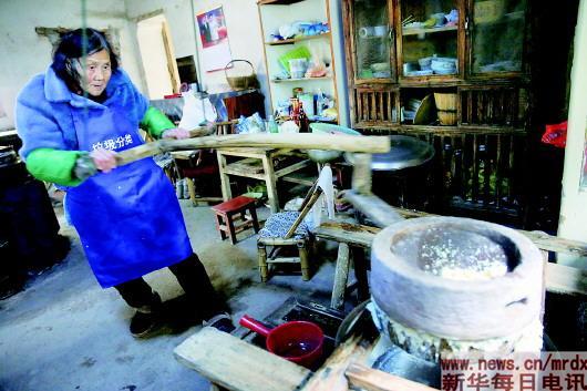 Mao Shihua grinds soybeans at her home. The 83-year-old sells affordable breakfast to students in Huangtankou Primary School in Huangtankou township in East China's Zhejiang proinve for the past 24 years. (Photo/Xinhua)