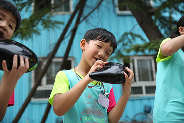 Guo practices the ocarina before the contest. (Photo/China Daily)