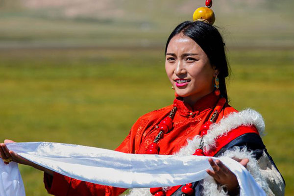 Bright red is widely used. Kangba costumes are very practical at the same time, and the left half (shown above) of the outer layer can be taken off and fixed on the waist. (Photo by Han Jiajun/chinadaily.com.cn)