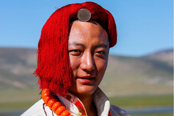 The red decorations - twisted red wires - on men's heads are part of the traditional dress. (Photo by Han Jiajun/chinadaily.com.cn)