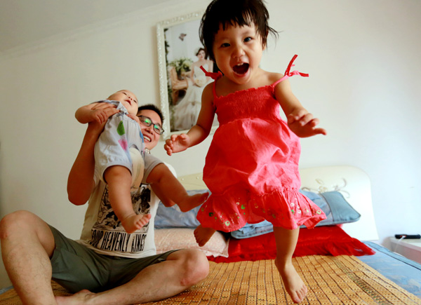 A girl shares a fun moment with her father and her brother in Xi'an, capital of Shaanxi province. (Photo by Chen Feibo / For China Daily)