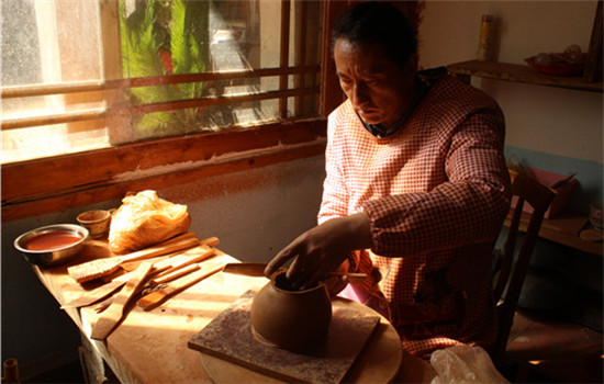 Tadrin Phuntsok is one of the best pottery makers in Nixi township, Yunnan province. His family has carried on the craftsmanship for generations. (WANG KAIHAO/CHINA DAILY)