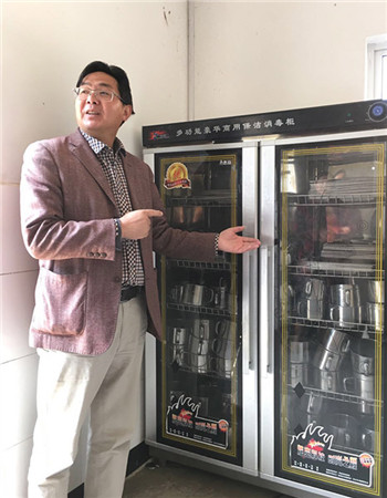 Zhang Yongming, head teacher of Gejia Primary School in Gejiu, a city of Yunnan province in Southwest China, shows kitchen facilities at school. (Zhang Chunyan/chinadaily.com.cn)