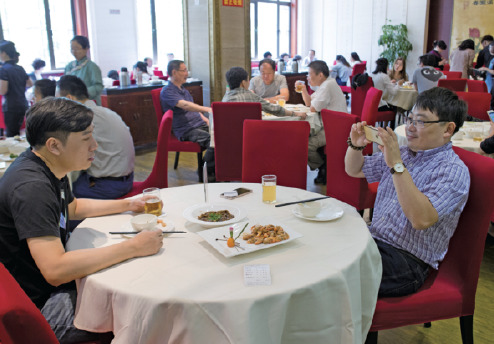 Lao Zheng Xing restaurant in Shanghai is known for its signature dishes like 18-second shrimp and red-braised pig intestine. It's the only State-owned eatery in the city to be honored by the Michelin Guide. The restaurant has been packed to capacity since the award. (GAO ERQIANG/CHINA DAILY)