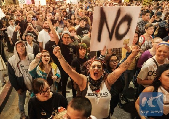 Demonstrators gather to protest a day after President-elect Donald Trump's victory, at a rally outside Los Angeles City Hall in Los Angeles, California, on November 9, 2016. (Photo/Xinhua)