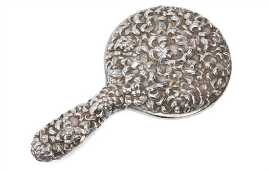 A silver hand-held mirror.