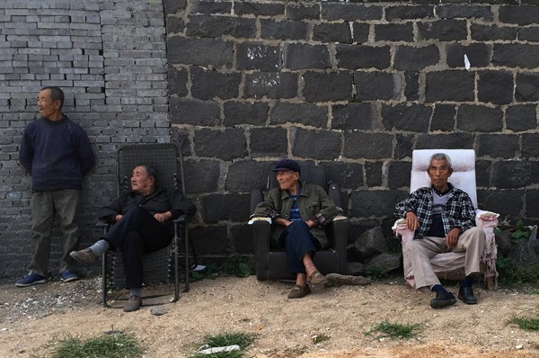 Several senior villagers catch some sun during a post-lunch break in Sangdao village, Longkou city, Shandong province. Exposure to sunlight boosts level of vitamin D, which can alleviate brittle bone disease, so sunbathing has become a popular recreational activity among elderly people in China. (Photo by Du Lianyi/China Daily)