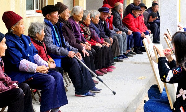 Volunteers paint portraits of residents at a nursing home in Liaocheng, Shandong province. (Photo by Zhao Yuguo/For China Daily)