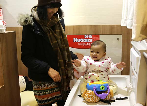 A mother tends to her baby in a nursing room at a shopping mall in Shanghai. YANG SHICHAO/XINHUA