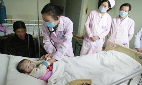 Doctors check on a child suffering from heart disease. (Photo/GT)