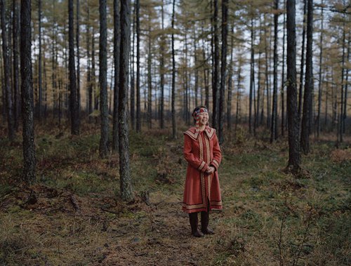 Budongxia stands in the woods where she has been keeping reindeer. (Photo/GT)