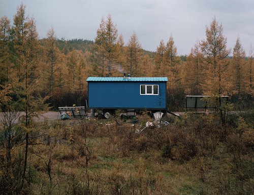 A movable house allocated by the local government is parked outside Budongxia's mountain home. In several years, after the reindeer eat all the moss and fungus in the region, the family will have to move to another region. (Photo/GT)