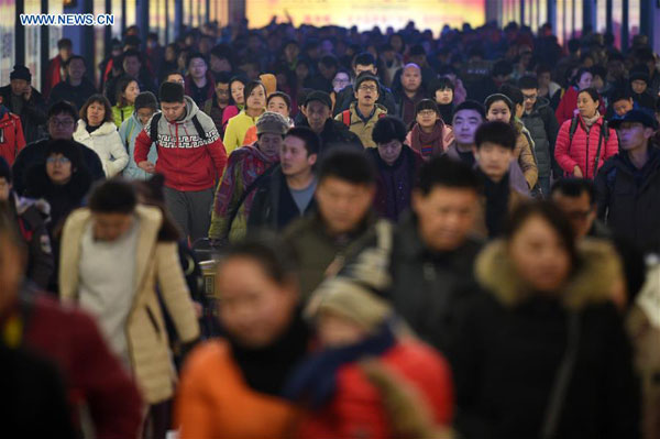 Arriving passengers exit the Beijing Railway Station in Beijing, capital of China, Feb. 12, 2016. (Photo: Xinhua/Ju Huanzong)