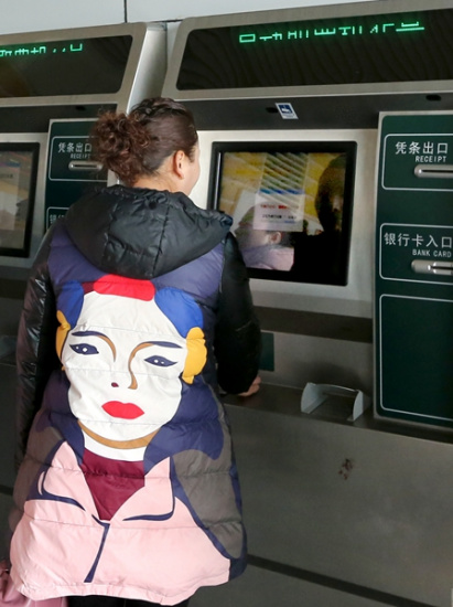 A passenger gets her ticket at Nantong Railway Station in Jiangsu province on Thursday after purchasing it online. Xu Congjun / For China Daily