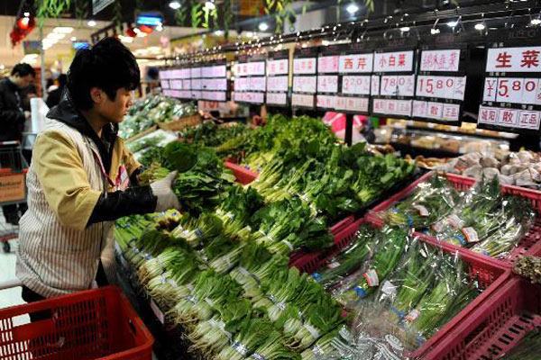 A staff member put vegetables in order at a supermarket in Qingdao, East China's Shandong province, on March 9, 2011. (Photo/Xinhua)