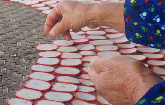 A lady carefully lays out sliced radish in a spiral. (Photo by Rosemary Bolger/chinadaily.com.cn)