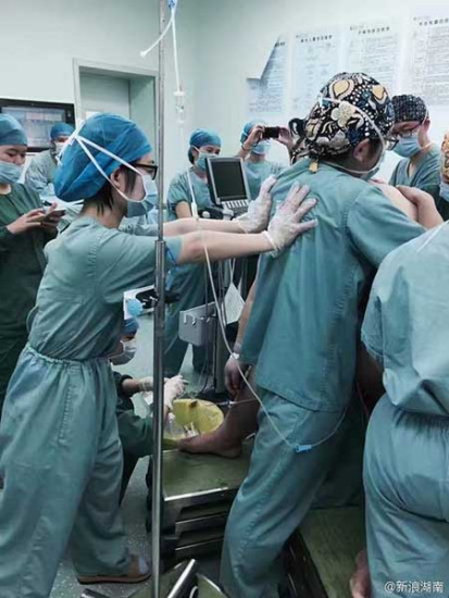 Medical staff members help the woman deliver the baby. (Photo from Sina Weibo)