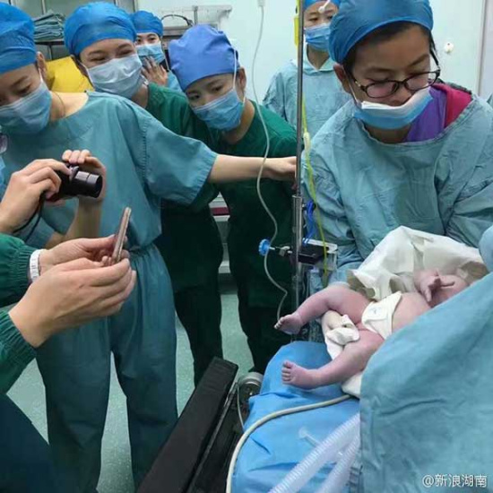 Medical staff members take photos for the newborn. (Photo from Sina Weibo)