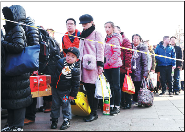 Passengers make their way home after arriving at Beijing Railway Station on Thursday, as the city witnessed a growing number of people returning as the Spring Festival holiday came to an end. (Photo by Zou Hong / China Daily)