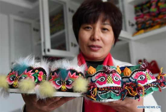 Collector Hu Shuqing displays her collection of tiger-head shoes in Zhengzhou City of central China's Henan Province, March 10, 2017. (Xinhua/Zhu Xiang) 